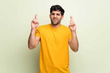 Parmak geçiş ve en iyi isteyen ile pembe duvar üzerinde genç adam