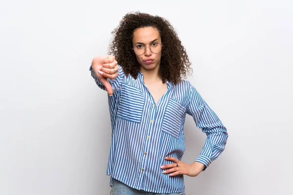 Çizgili gömlek ile Dominikli kadın olumsuz ifade ile işaret aşağı başparmak gösteren