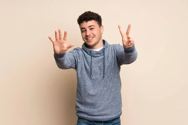 Mladý Muž Nad Izolovanou Zdí Počítání Sedm Prstů — Stock fotografie