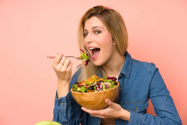 Young blonde woman with salad