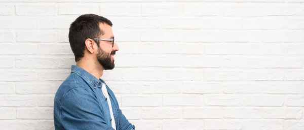 Hombre Guapo Con Barba Sobre Pared Ladrillo Blanco Posición Lateral —  Fotos de Stock