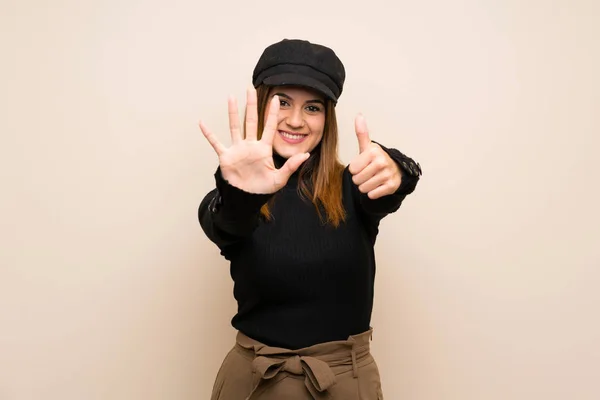 Fashion woman with hat counting six with fingers