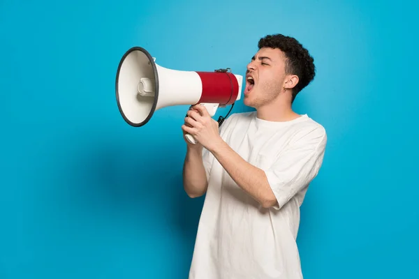 Jonge Man Blauwe Achtergrond Schreeuwen Door Een Megafoon — Stockfoto