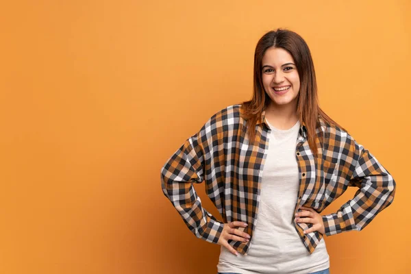 Jovem Mulher Sobre Parede Marrom Posando Com Braços Quadril Sorrindo — Fotografia de Stock