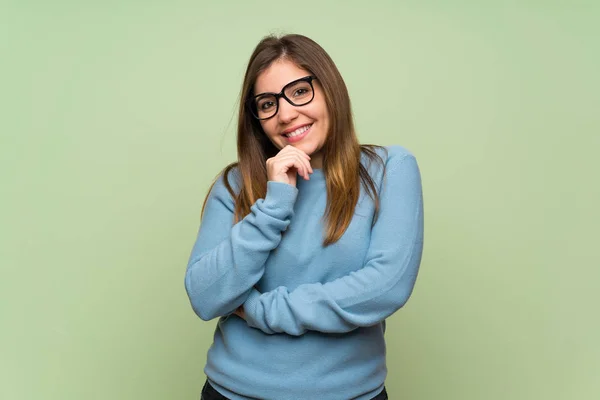 Chica Joven Sobre Pared Verde Con Gafas Sonriendo —  Fotos de Stock