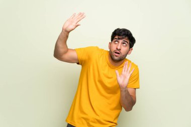 Pembe duvarın arkasındaki genç adam biraz gergin ve korkmuş.