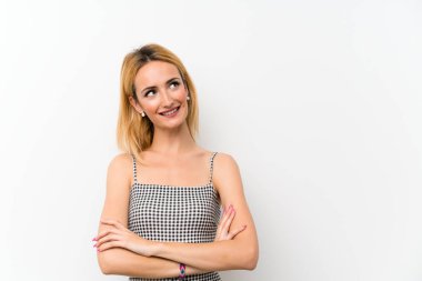 Genç sarışın kadın, soyutlanmış beyaz kadın gülümserken yukarı bakıyor.