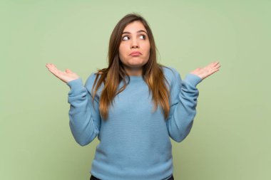 Yeşil duvar üzerinde genç kız şüphe jest yapma