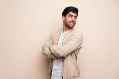 Kollarını çapraz ve mutlu izole duvarın üzerinden genç adam