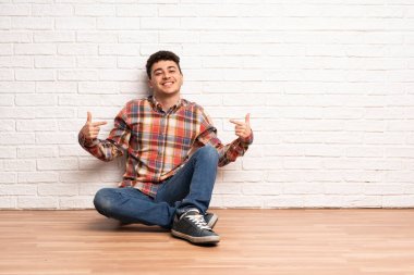 Genç adam gururlu ve kendinden memnun katta oturan