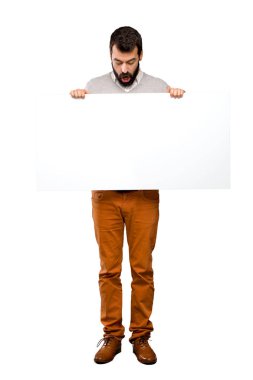 Boş bir afişini izole beyaz arka plan üzerinde tutarak sakallı yakışıklı adam