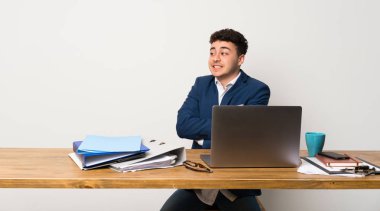 Bir ofiste iş adamı gülümserken yukarı bakıyor