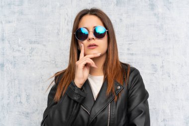 Duvarı aşmış genç bir kadın bir fikir düşünüyor.