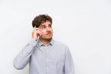 Sarışın adam izole beyaz duvar üzerinde şüpheler olan ve yüz ifadesi karıştırmayın