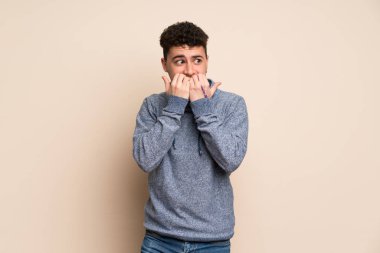 Tecrit edilmiş duvarın üstünde genç bir adam gergin ve korkmuş bir şekilde elleriyle suni teneffüs yapıyor.