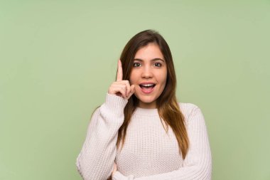 Beyaz kazak ayakta ve yan bakıyor genç kız