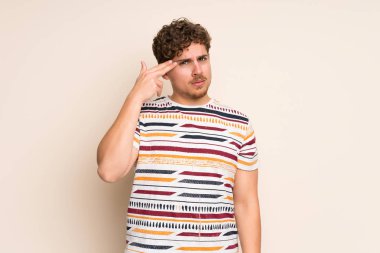 İntihar jesti yaparken sorunlar ile izole duvar üzerinde Blonde adam