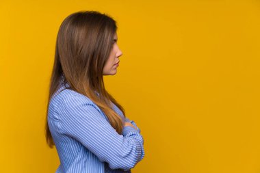 Çizgili gömlek ile genç kız kollarını çapraz ve yan görünümlü tutmak