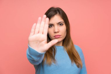 Young girl with blue sweater making stop gesture with her hand