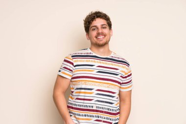 Sarışın adam izole duvar üzerinde gülüyor