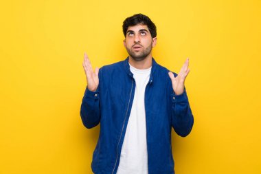 Mavi ceket ve sarı duvar tarafından kötü bir durum sinirli üzerinde olan adam