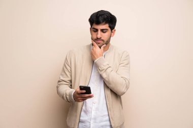 Duvarı aşan genç adam düşünüyor ve bir mesaj gönderiyor.