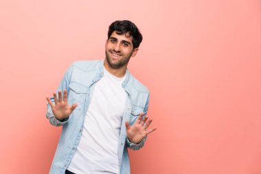 Pembe duvar gülümseyen üzerinde genç adam
