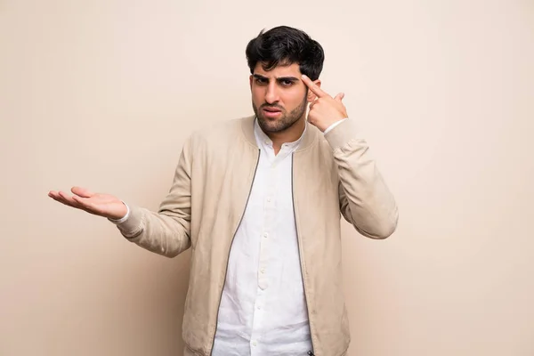 Joven Sobre Pared Aislada Haciendo Gesto Locura Poniendo Dedo Cabeza —  Fotos de Stock