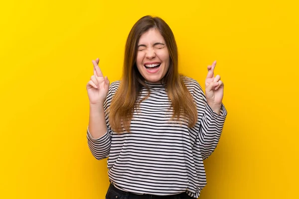 Young Girl Yellow Wall Fingers Crossing — ストック写真