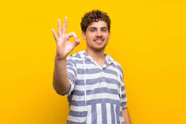 Ξανθός Άνθρωπος Πάνω Από Κίτρινο Τοίχο Δείχνει Ένα Σημάδι Δάχτυλα — Φωτογραφία Αρχείου