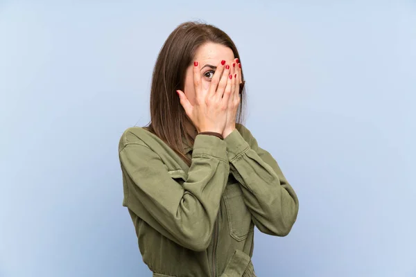 Jovem Mulher Sobre Parede Azul Isolada Cobrindo Olhos Olhando Através — Fotografia de Stock