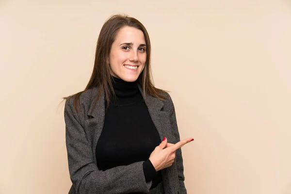 Giovane Donna Oltre Parete Isolata Puntando Dito Verso Lato — Foto Stock