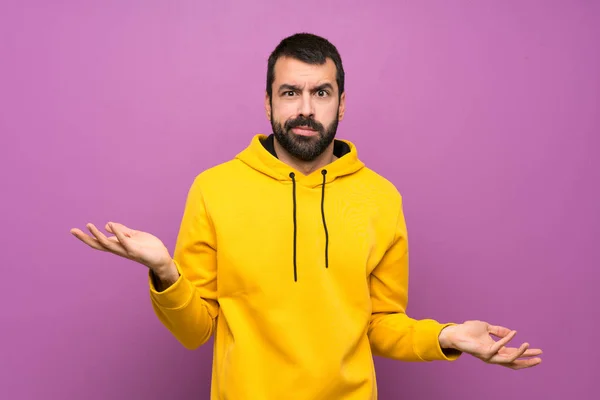 Handsome man with yellow sweatshirt unhappy for not understand something