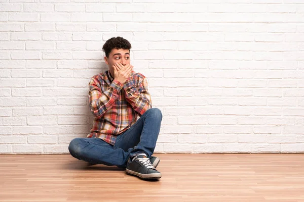 Mladý Muž Sedící Podlaze Zakrývající Ústa Pohled Stranu — Stock fotografie