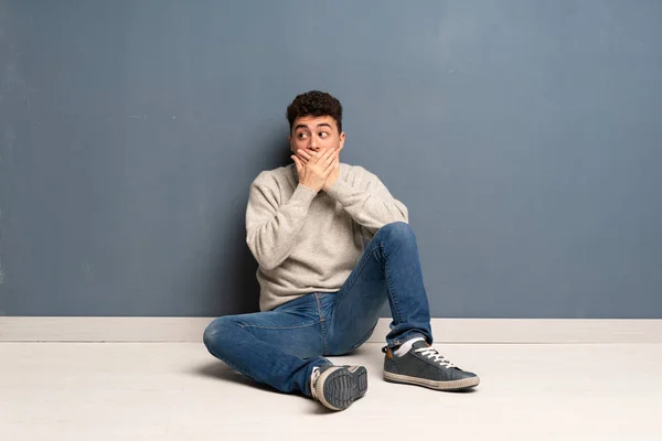 Mladý Muž Sedící Podlaze Zakrývající Ústa Pohled Stranu — Stock fotografie