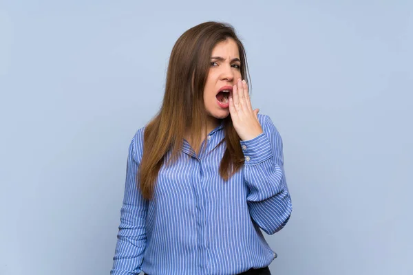 Jovencita Sobre Aislada Pared Azul Bostezando Cubriendo Boca Abierta Con —  Fotos de Stock