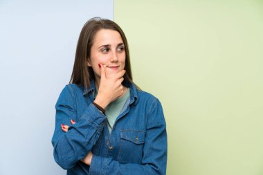 Renkli arka plan üzerinde genç kadın bir fikir düşünme