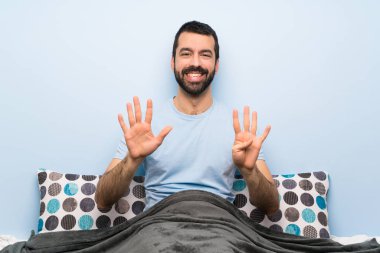 Yatakta parmaklarıyla dokuz sayan adam