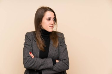 İzole edilmiş duvarın üzerinde duran ve bir fikir düşünen genç bir kadın.