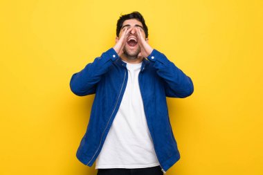 Sarı duvar üzerinde mavi ceketli adam bağırıyor ve bir şey ilan