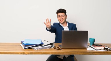 Bir ofiste iş adamı mutlu ve parmakları ile dört sayma