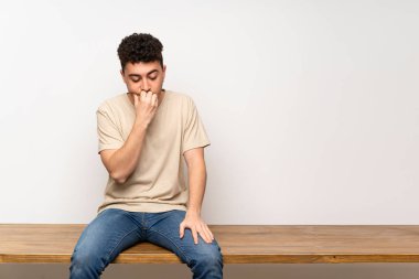 Masada oturan genç adamın şüpheleri var.