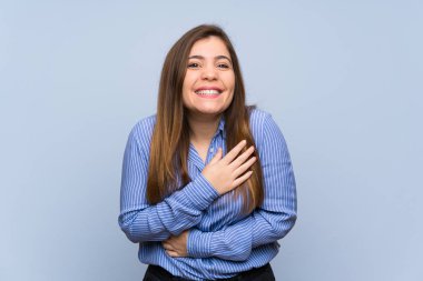 Izole mavi duvar üzerinde genç kız çok gülümsüyor