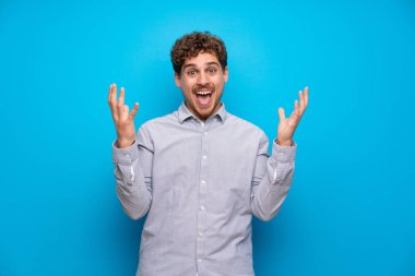 Mavi duvar çok gülümseyen üzerinde sarışın adam