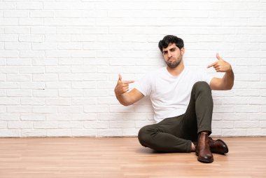 Genç adam gururlu ve kendinden memnun katta oturan