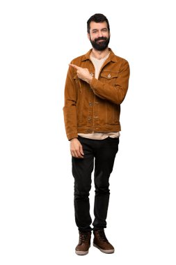 Ürün yalıtılmış beyaz arka plan üzerinde sunmak için tarafına işaret eden sakallı yakışıklı adam