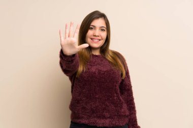 Young girl counting five with fingers