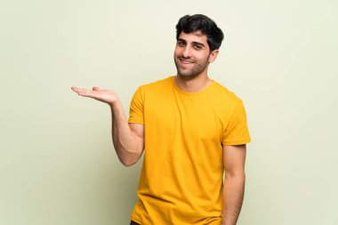 Pembe duvar üzerinde genç adam bir reklam eklemek için palmiye üzerinde boşaltmak hayali tutarak