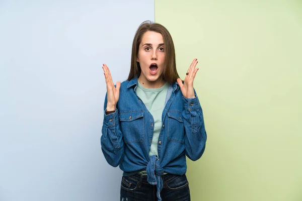 Young woman over colorful background with surprise facial expression