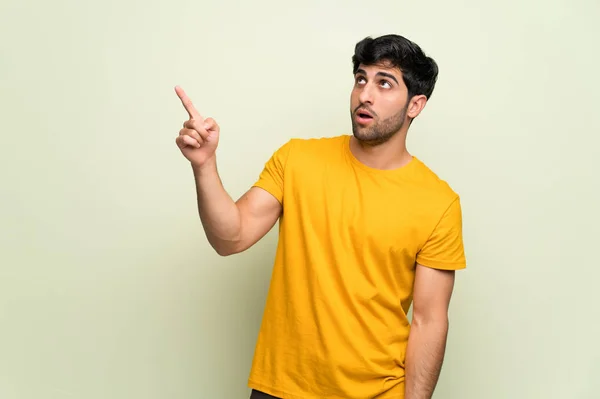 Joven Hombre Sobre Pared Rosa Apuntando Lejos —  Fotos de Stock